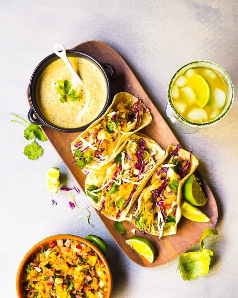 Grilled fish tacos with a creamy tomatillo sauce and a side of mango-radish salsa are my way of enjoying a delicious Mexican meal at home.