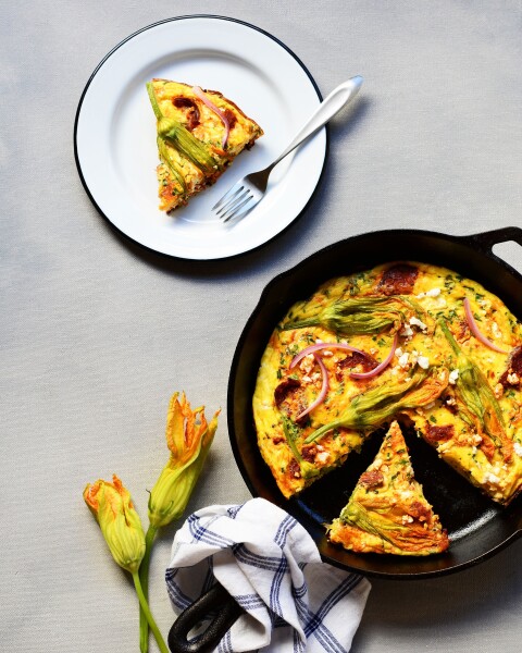 Perking up the quintessential frittata with these gorgeous fresh squash blossoms with Iberico chorizo and feta cheese, along with chopped onions, and herbs.  