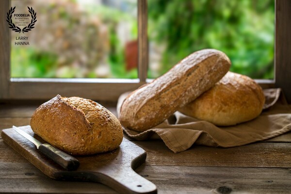 I have always loved beautiful artisan bread and bought these at a local market and created this set in my kitchen.  I made the window frame and Photoshopped an image I took in Italy into it.  I did the photograph for my own portfolio and for sale on my website (www.larryhanna.com)