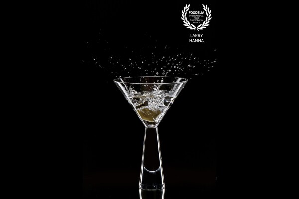 Olive dropping into a martini.  I did this photograph as a demonstration to a group of students on how to photograph glassware and capturing splashes.