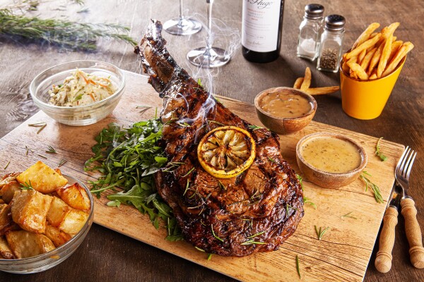 Perspectives can be tricky to manage with food photography. For me, one of the most important elements in this shot is actually the chunky rustic cutlery, which gives a real sense of scale to this MONSTER steak! This was a last-minute addition to the styling. I also selected smaller dishes to surround the meat hero, so as to not dwarf it. The backlit rise of torched rosemary smoke provides the final magic.