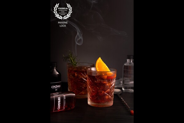 A "smoky" image of Negroni cocktails, made for a client that sells "Cocktails in a Kit" that was created to be delivered to people's homes during the pandemic. Because of social-distancing, this was created entirely by myself; including making and styling the cocktails itself, as well as burning the rosemary and trying to capture the "perfect" string of smoke from it. 