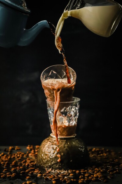 It’s time for an iced coffee, with milk of course! I always love action shot involving pouring and mixing; so one day it came to my mind for a shot of pouring coffee and milk together.

Here the coffee and milk are poured onto a tipped glass filled with ice cubes. The inconsistent speed of the liquids coming out of the pot and jug making a beautiful capture of the milk, coffee; also when they are already mixed together in the glass.