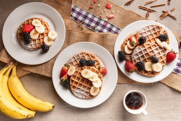 A delicious gluten free waffles, fruit and hot coffee for breakfast. An overhead shot, with a very soft light and reflector to fill in the shadows.