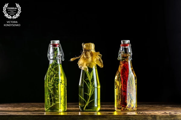 Different sorts of cooking oil — homemade farmer products. Presentation assortment of sunflower oil with pepper and dried dill, corn oil with rosemary and olives oil with thyme.