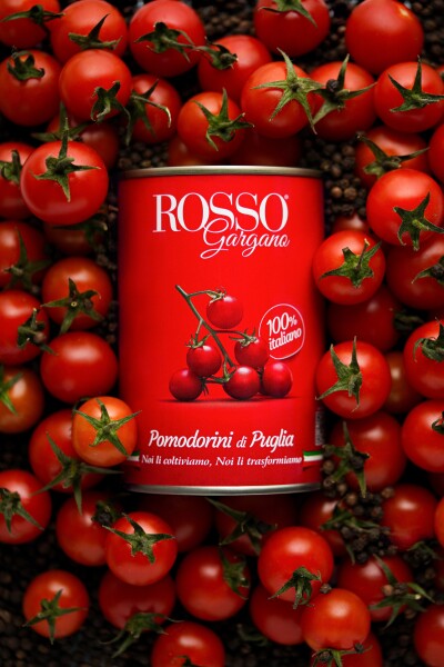 Ripe cherry tomatoes burst from the tin in an explosion of texture and color, lit by gentle side lig...