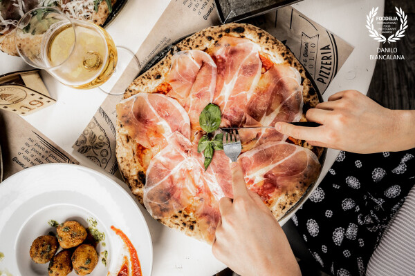 A taste of Parma on your table!Pizza with Parma ham is an experience of Italian conviviality, served...