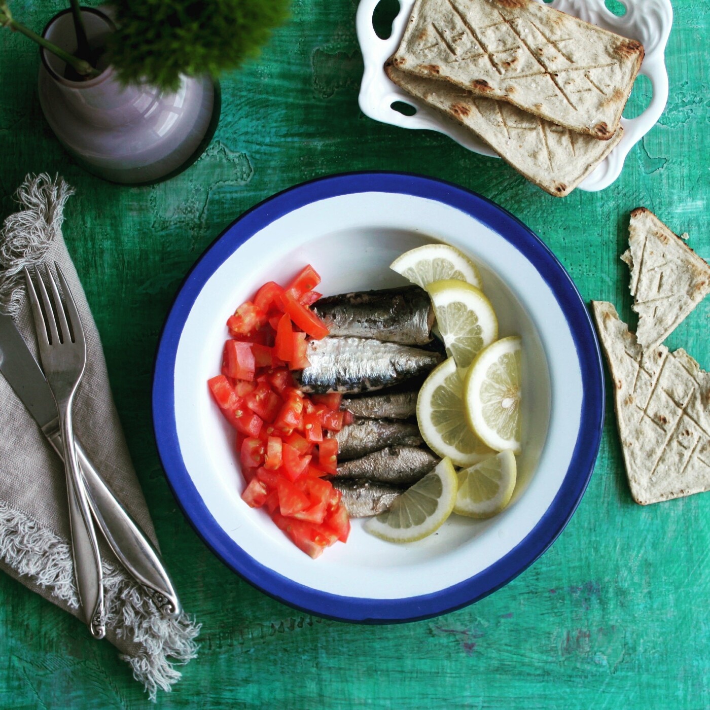 Smoked sprats with fresh tomatoes and a squirt of lemon on corn toasts.