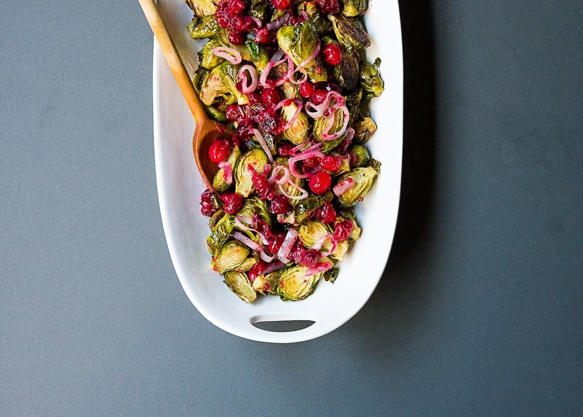 I simply enjoy the natural organic beauty in food, and this platter of roasted brussels sprouts mixed with a cranberry bourbon maple butter sauce with shallots is no exception.  It was photographed under natural light at my home studio in late fall.  By keeping the background of the image to a minimal, the contrast between the white platter and colorful contents helps to convey a sense of the taste variety in this dish: sweet, sour and bitter.  A sentiment of holiday celebration  and group gathering is also presented here.