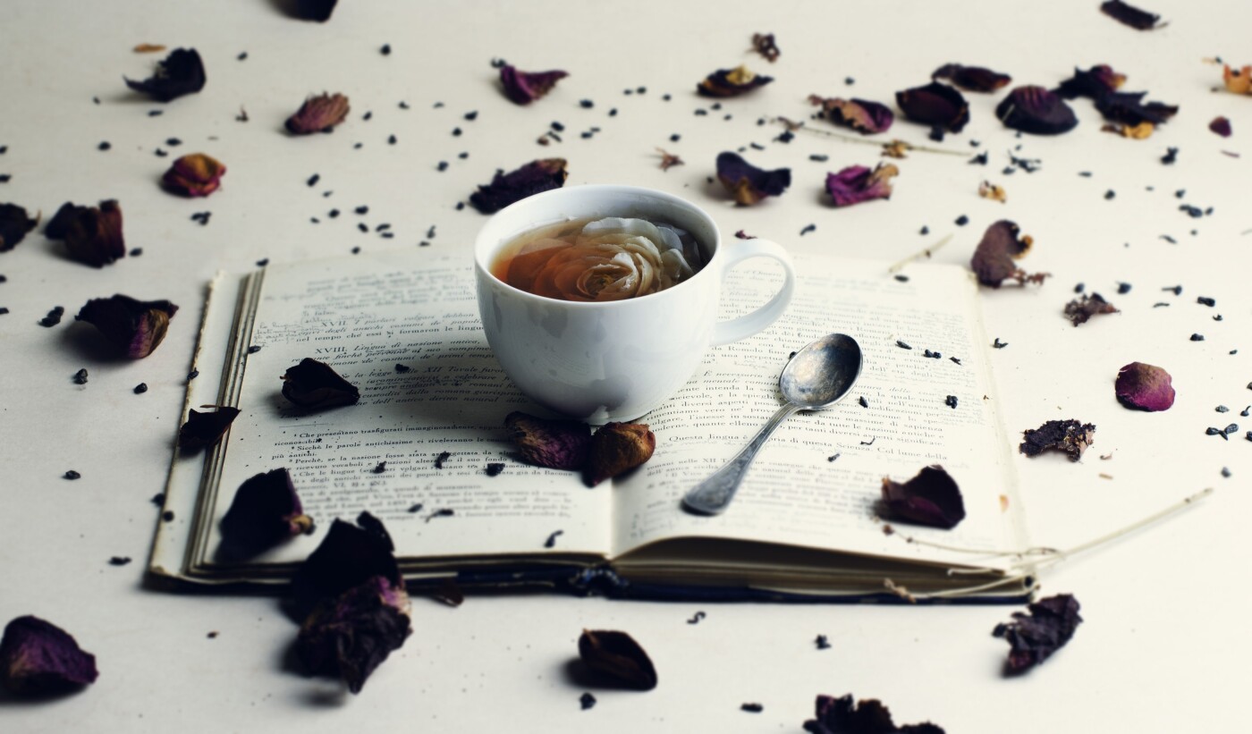A classic stereotype, a cup of tea and an old vintage book. The addition of the rose inside the teacup and the others petals around, creates the right balance in a simple picture.