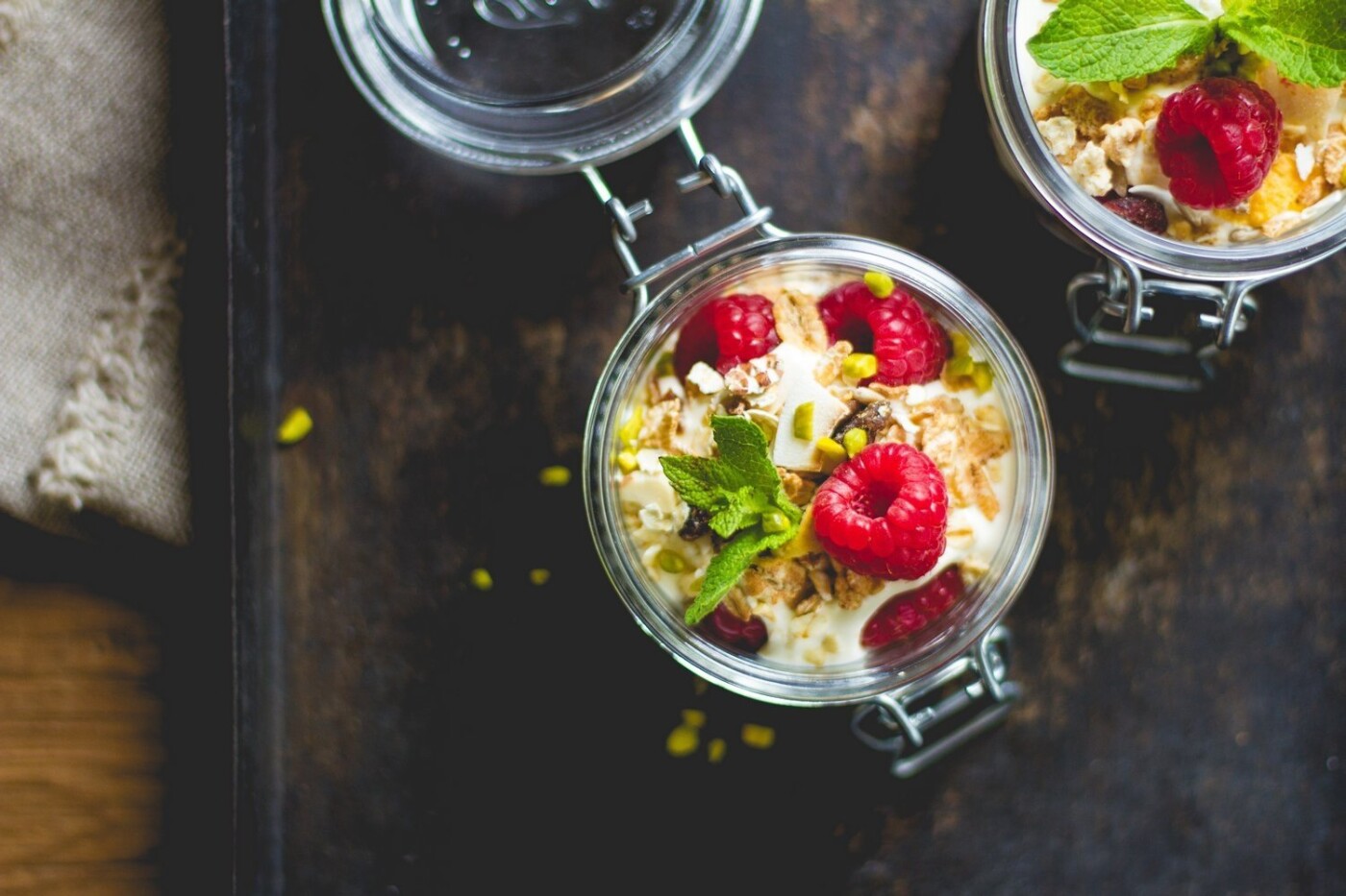 This berry yogurt breakfast parfait is a quick and healthy breakfast for mornings when you are on the go! Homemade granola with oats, honey, coconut, raisins, sunflower seeds, almonds, pumpkin seeds, cranberries, cashew nuts and hazelnuts with layers of greek yogurt, fresh raspberries and crushed pistachios.