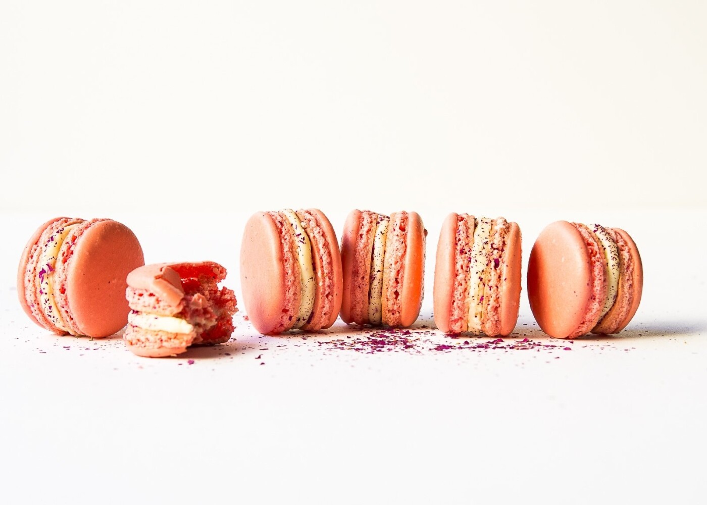 Homemade macarons, first attempt turned out pretty good. The filling in the middle of these macarons is white chocolate ganache encircling a dallop of raspberry jam and sprinkles of dried rose bud petals. French macarons by nature are quite photogenic. This image of them shows off the lovely tones, textures and the crumbliness of a delicious bite.