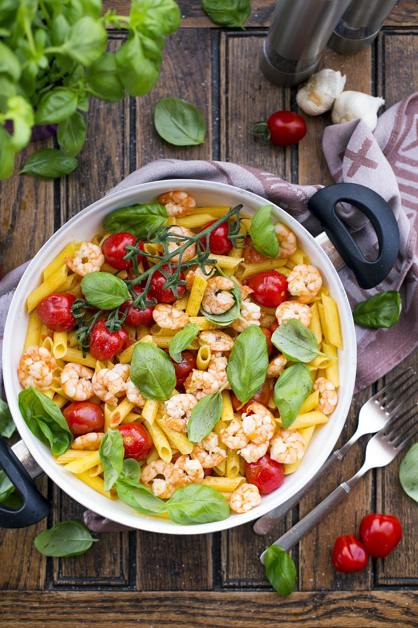 Gluten-free Black Tiger Shrimp Penne topped with cherry tomatoes and fresh basil leaves as a perfect home-cooked meal, which will be featured in a cookbook.