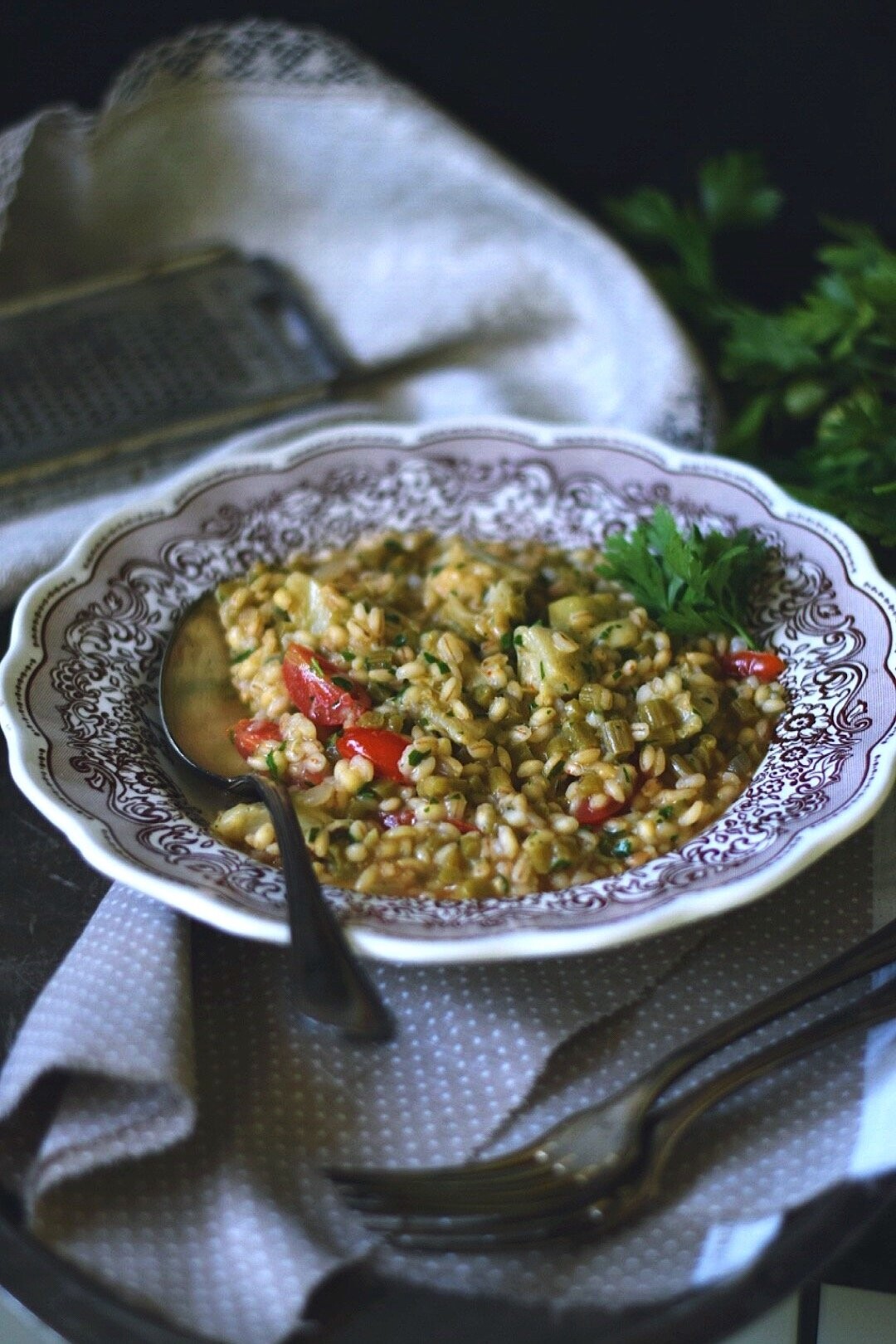 Delicious vegan lunch. Pearl barley risotto with amaranth stems, artichokes, tomatoes and vegan smoked cheese. 