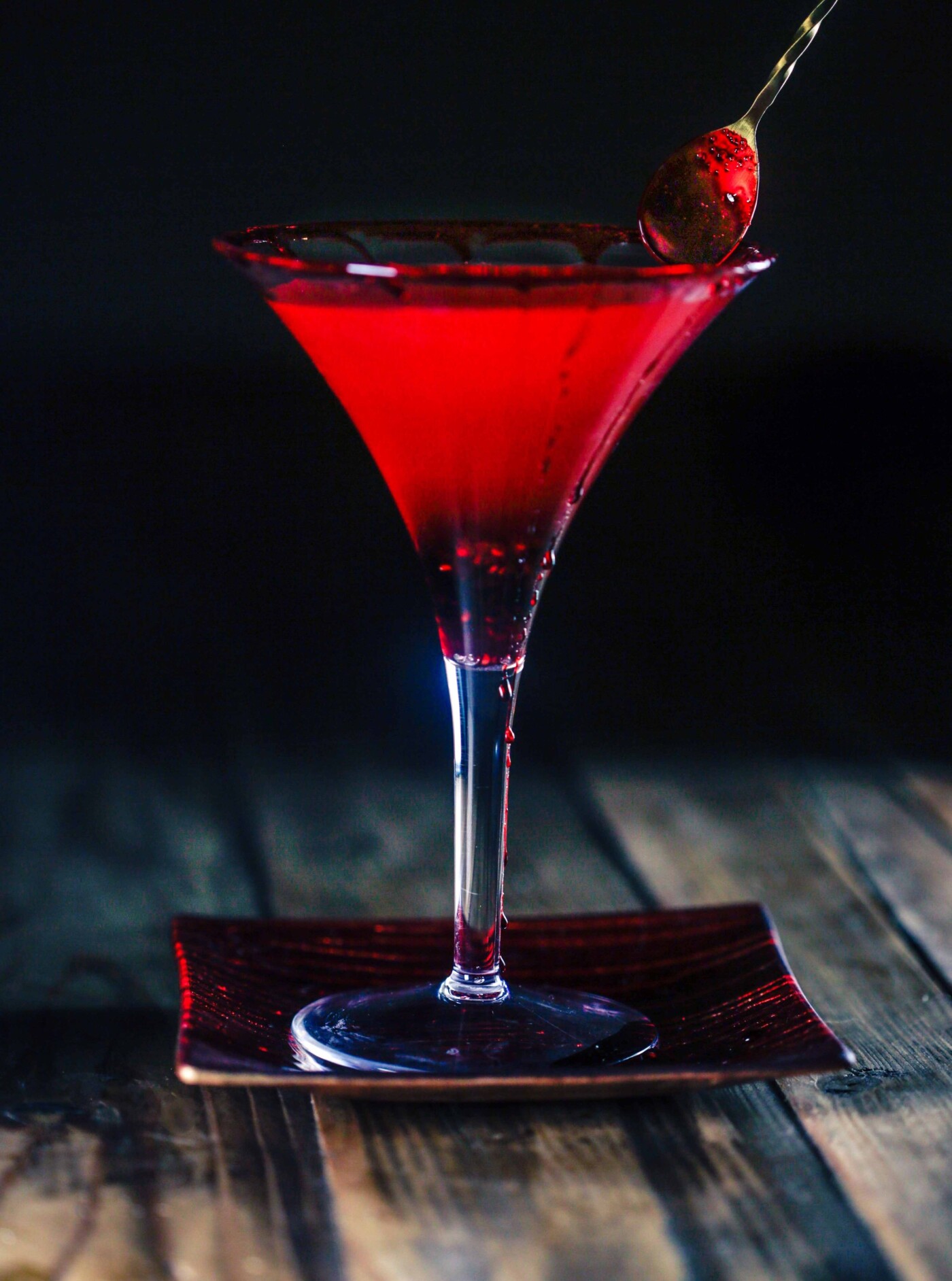 This is a hand crafted martini created by craft mixologist Tara Salinas. Ingredients include vodka, raspberry pureè, sparkling blood orange juice, a candied orange and a rim of movie blood; which is corn syrup and red food coloring. This particular cocktail is from a series of drinks that were themed after each season of "American Horror Story". This beverage is a representation of season 5 "Hotel". The series was shot for a food blog that can be found here: https://tvdinners.me