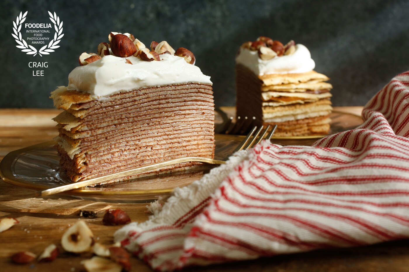 Chocolate Hazelnut Crepe Cake photographed for the New York Times @nytfood. This is a delicious cake made of hazelnut crepes stacked with chocolate cream between each layer, topped with whipped cream, hazelnuts and dust with cocoa. Styled by @the_bojon_gourmet and @snixykitchen.