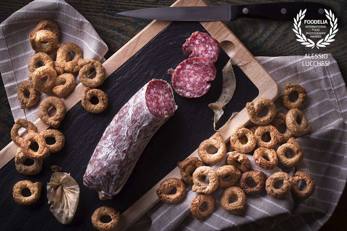 Italian Chopping board with "tarallini" and salami.<br />
The "tarallo" or "tarallino" is a typical product of Puglia, Campania, Basilicata, Calabria and Sicily; as such it has been officially included in the list of traditional Italian food.