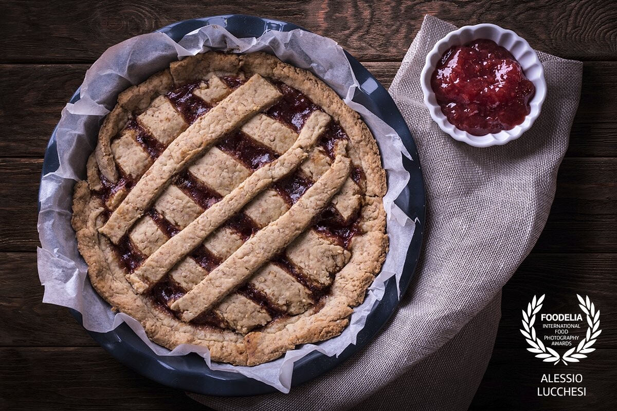 Homemade tart. Main ingredients: whole wheat flour and strawberry jam. The photograph was taken on rustic table to highlight the craftsmanship of the product