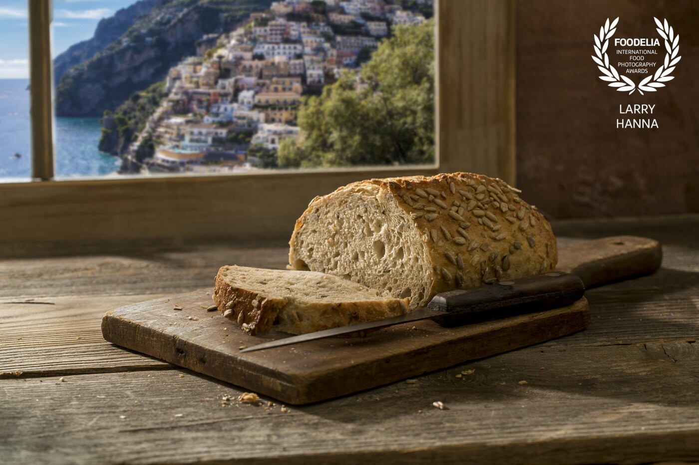 I photographed this loaf of bread for my portfolio.  Photographed using natural light in my kitchen with a set I constructed.  The window image was added from a photograph I took in Positano last year.
