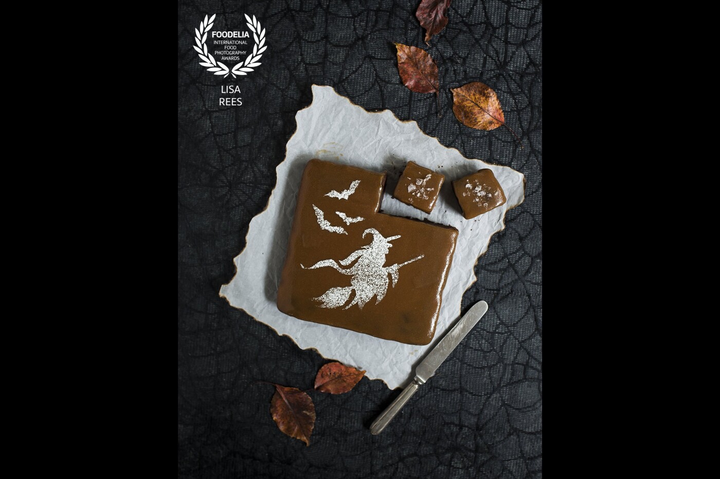 This salted caramel fudge brownies was created in celebration of Halloween.  The fun part in making it was to make the stencil for the witch on the broom and the bats.  The burned edges of the parchment paper and the lacy background help to pull the elements together to convey that sense of bewitching yumminess.