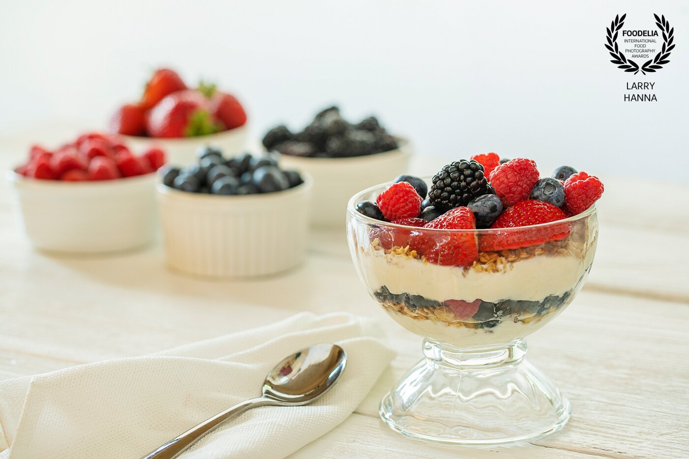 I love the early mornings with the light streaming through my kitchen window.  My family loves a fresh berry parfait during the summer.  I createdd this fresh berry parfait with Greek yogurt and granola and photographed it in my kitchen with window light.