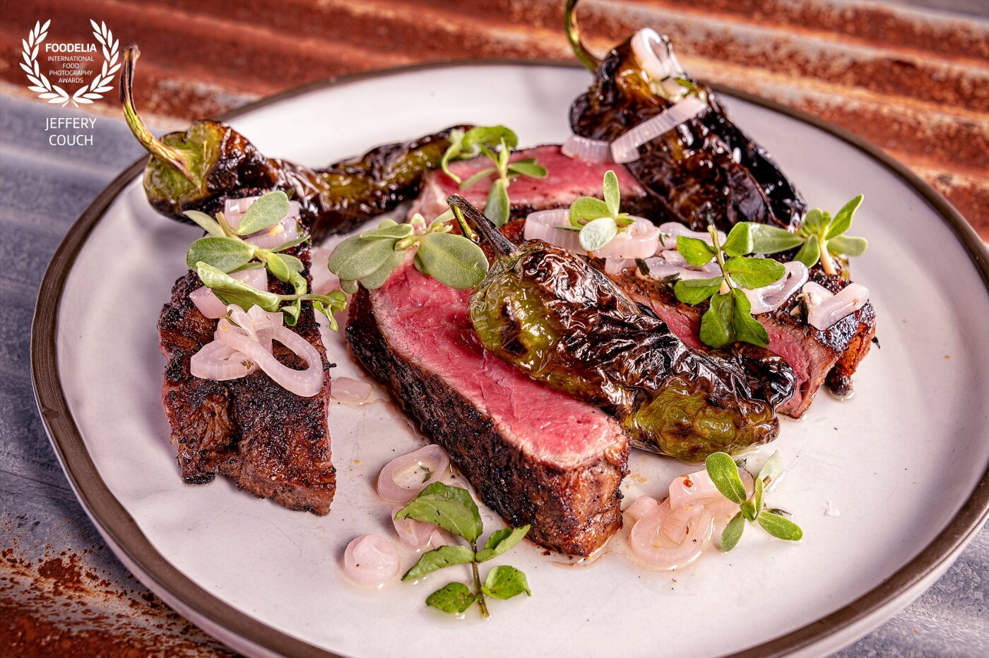 Photo shoot for two-star Michelin Chef Josiah Citrin was used in a promotional presentation of the new Openaire restaurant in Los Angeles. Coffee crusted dry aged NY strip loin, pickled onions, fresh oregano, and charcoal roasted shishito peppers. <br />
@josiahcitrin<br />
@jeffcouchfood