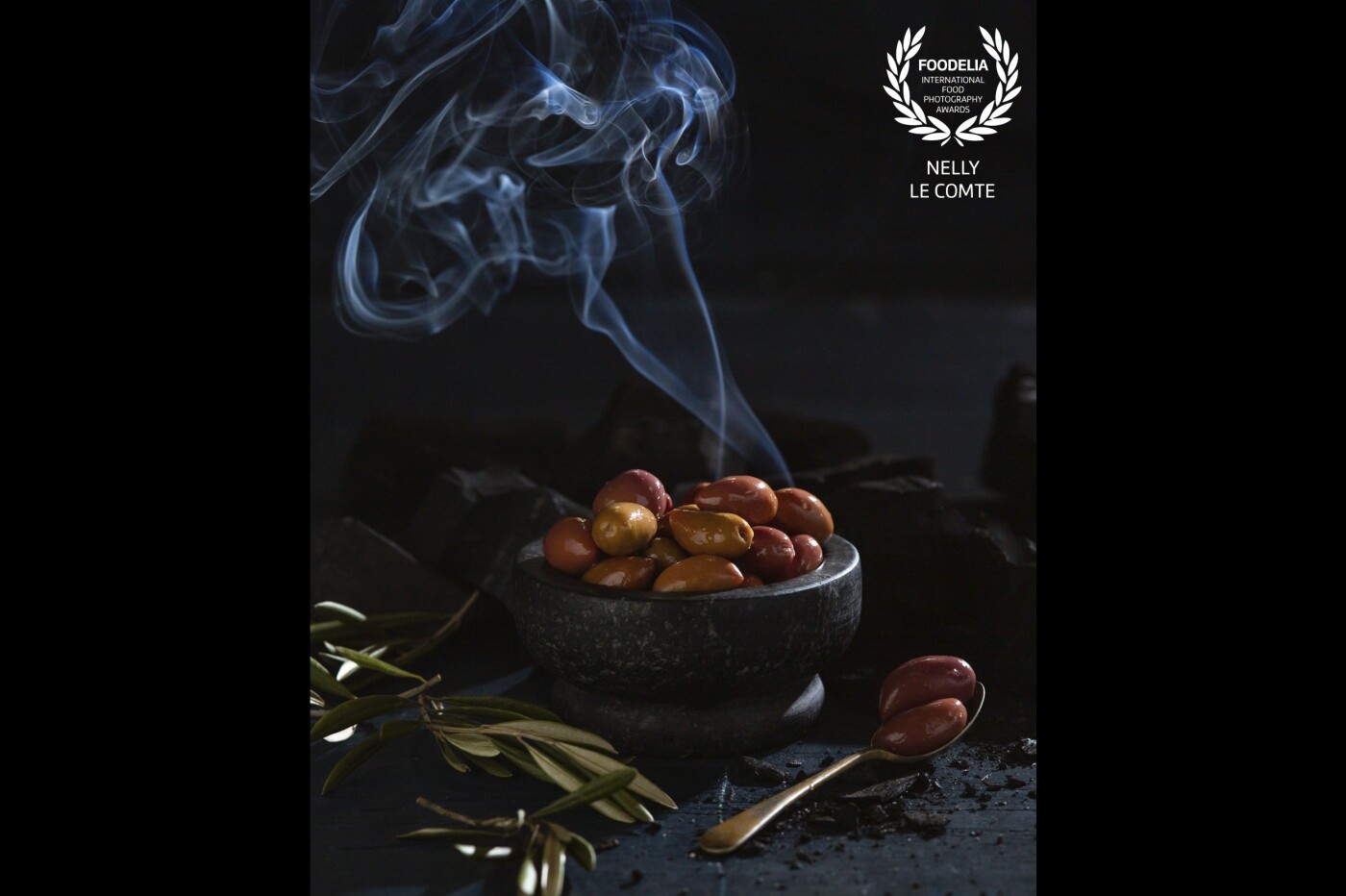 Kalamata and Manzanilla olives, hand smoked over cherry wood on @grumpygrandmas farm, giving them a rich, smokey flavor. We ate quite a few during the shoot as they are so moorish!<br />
Photographed in my studio where I like to balance studio light and natural light. Playing with shutter-speeds to get the right amount of smoke. Food styling by @foodstylist_pete_may and art direction by @tinabyron