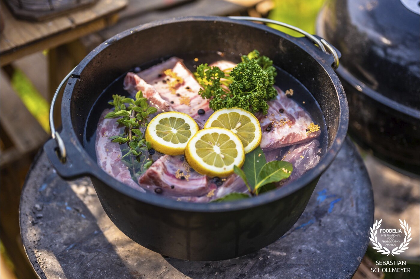 Preparing baby back ribs in a Dutch Oven to put them later on the grill. They will be cooked for 2-3 hours with a lot of spices and some lemon slices.