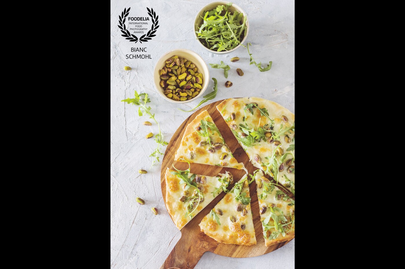 Easy pizza. After all, the Italian kitchen is all about simplicity, flavor and the best ingredients. This pizza topping contains only 3 ingredients: mozzarella, pistachios, and arugula. Simply tasteful and a wonderful piece to shoot ‘flat lay’.