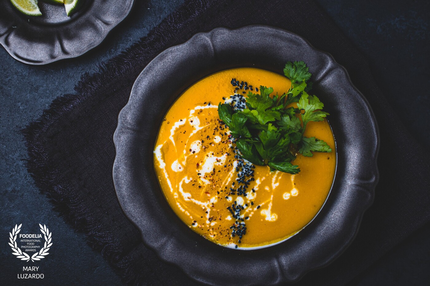This Creamy Coconut Ginger Carrot Soup is Our way to fight the cold weather during fall and winter days. Plus it is so beautiful and photo-ready. Blended soups can be tricky to photograph. But they have a lot of potentials. Using garnish as a prop in a way I faced this shoot. A drizzle of coconut on top, with some nigella seeds and herbs, added the texture it needed. 