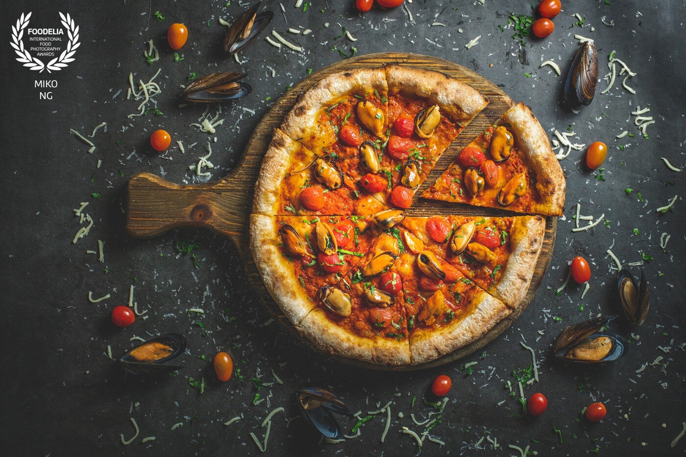 Mussel cherry tomatoes pizza food shoot for a bistro cafe in Kuala Lumpur, Malaysia. The pizza topped with mussel, cherry tomato, cheese and baked under real charcoal.