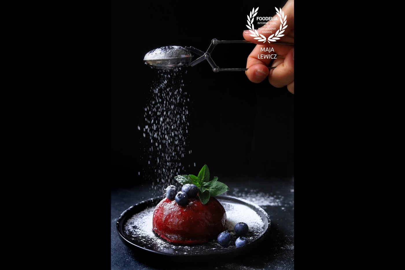 Powdered sugar rain on top of a vegan forest fruit mousse ball. I am a big fan of action shots and using hands in food photography. I believe they bring food to life in a completely new way. An action shot like this one looks more dynamic and natural if the hands are included, adding, at the same time, so much to the storytelling, don't you think?