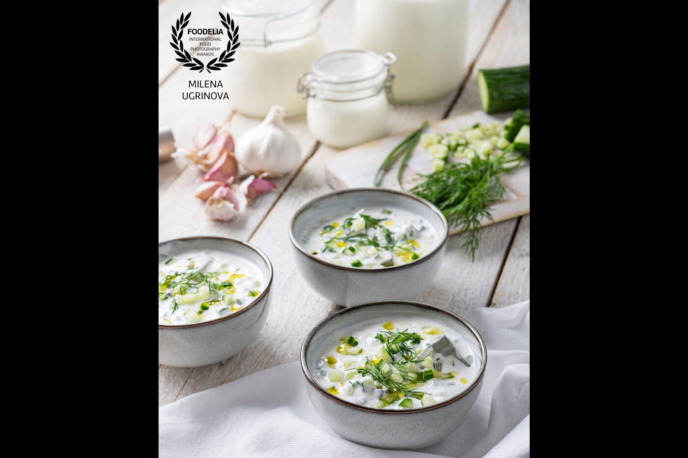 Have you tried the Bulgarian Tarator? It's a very simple and refreshing cold raw soup made of yoghurt, cucumber, dill, garlic, olive oil, and if you like, you can add some walnuts. The main ingredient is the Bulgarian yoghurt which is thick, not sweet, and combines perfectly with a pinch of salt. You'll need to add some water to turn it into a soup. If you know Tzatziki, yes, it's similar, but never the same. In the photo, you can notice all the ingredient for Tarator alongside my homemade yoghurt. Served with some ice is perfect for the hot summer.