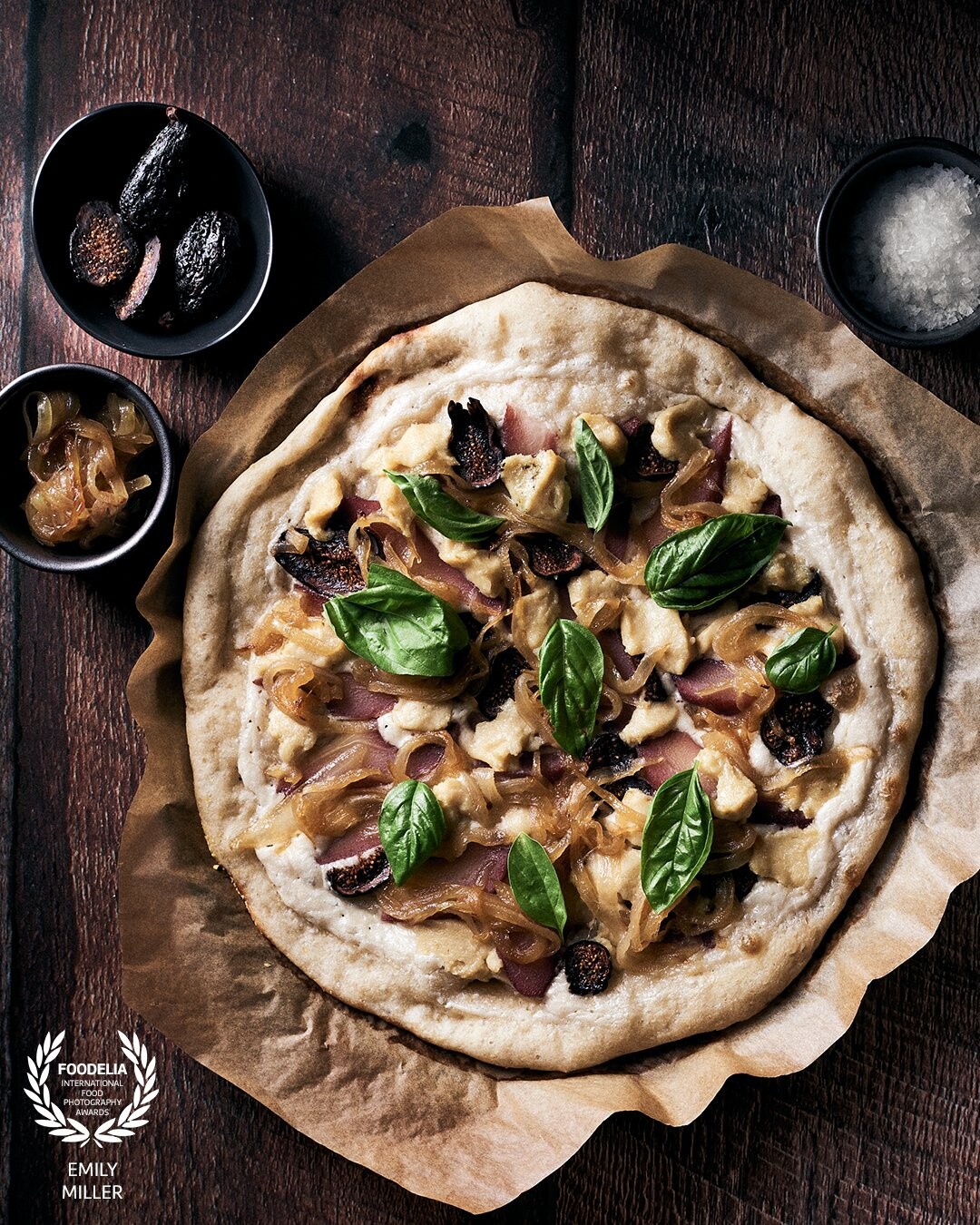 Homemade pizza with cashew cream, topped with red wine poached pears, vegan blue cheese, dried Mission figs, and caramelized onion. Topped with fresh basil from our garden. Quite possibly the best pizza I have ever made.  Lighting:  strip softbox at 11:00. Settings: Nikon D810, 50mm/1.8, ISO 100, 1/160 sec, f/6.3.