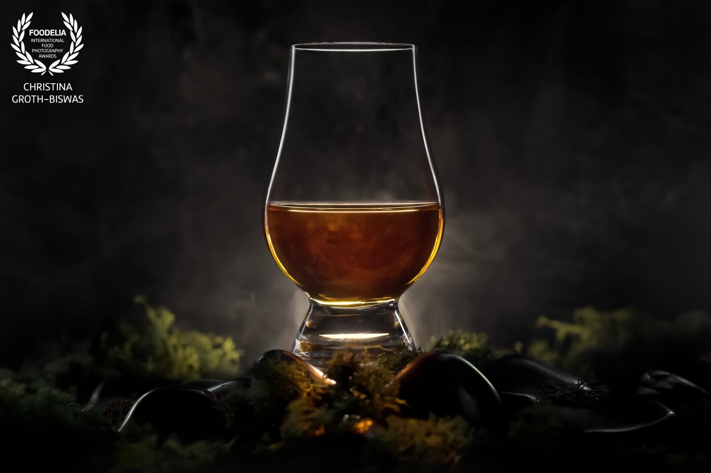 This is a traditional Glencairn whiskey glass. I wanted to portray it in a way that gives the viewer an impression of the Scottish landscape with moss, rocks and some mystic light.