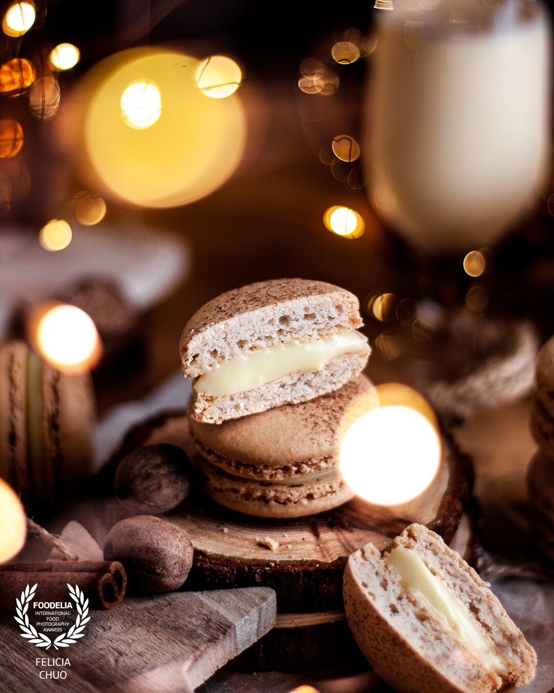 Eggnog macarons made and shot for the festive season, as hinted by the fairy lights, spices, and subtle wooden decoration peeking at the front. Shot with natural light.