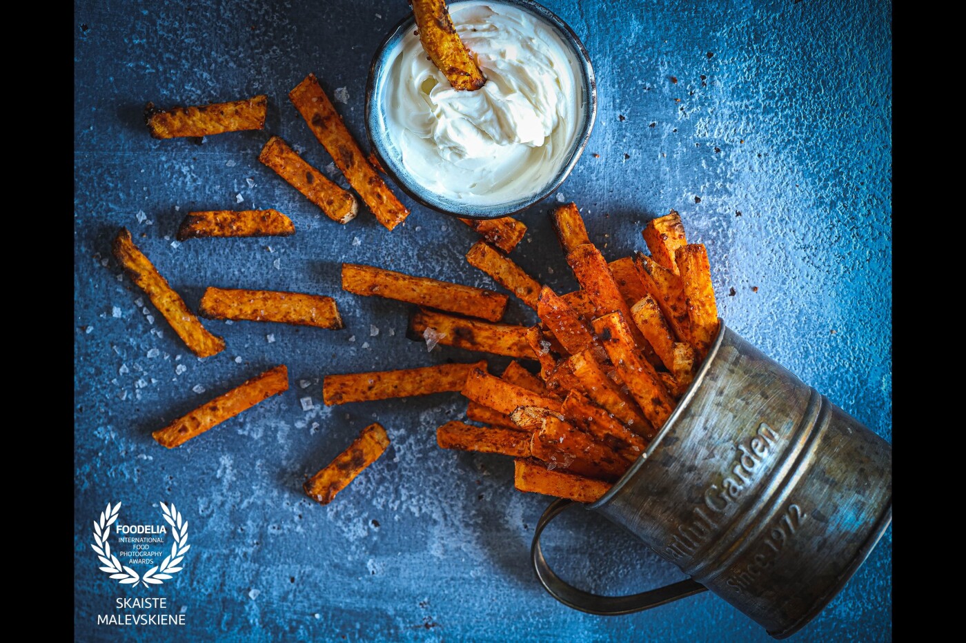Healthy and delicious sweet potato chips with garlic and chili  powder. In this picture I wanted to emphasize the color and the texture of baked potato chips and contrasting blue background played the role perfectly.