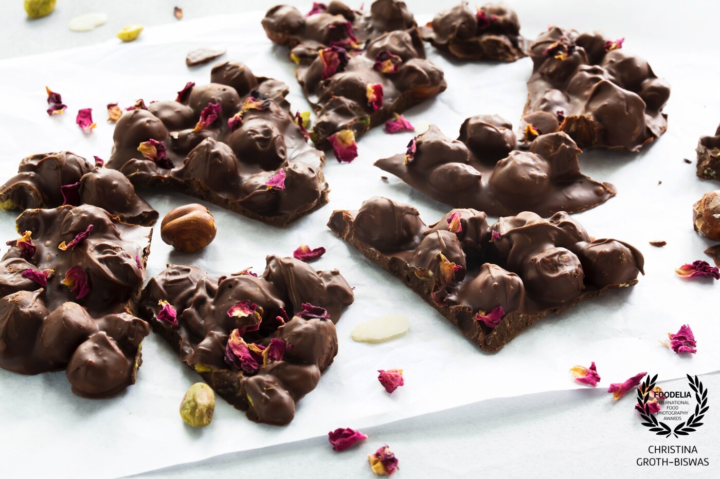 Dark chocolate and nuts, sprinkled with rose petals. I decided to use a white background for this picture, not my usual black. <br />
I also did not use any artificial lighting, just window light and a reflector.