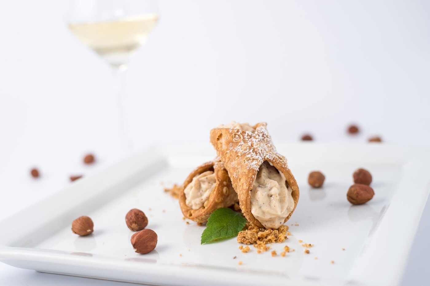 Cannoli with hazelnut cream - The idea was to showcase the ingredients and to get people to strive for the dessert. The white wine in the background is a great selection that goes with it.