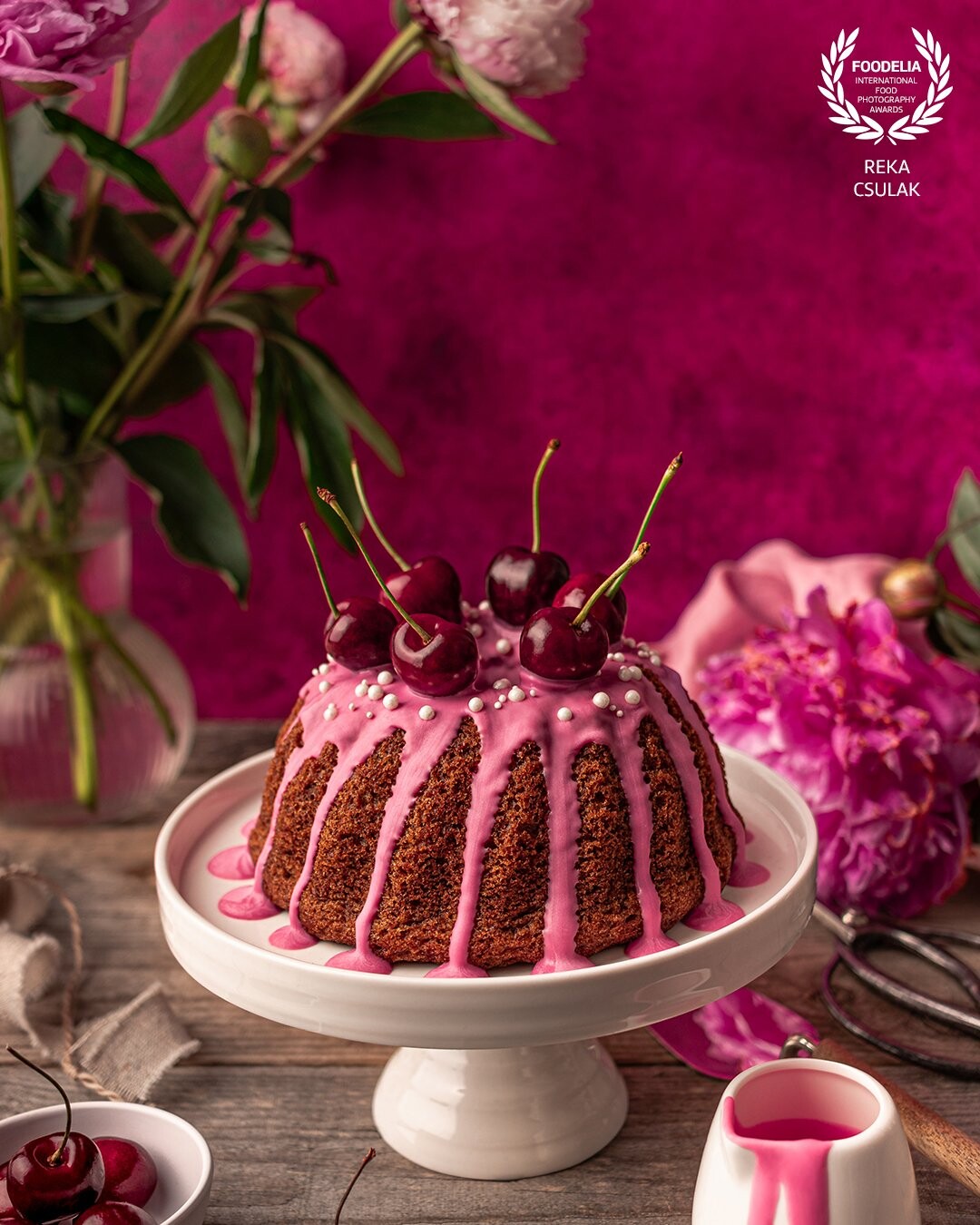 Delicious bundt cake with cherries and candy melts in the embrace of peonies and different shades and textures of pink, created as part of a visual update for my website.
