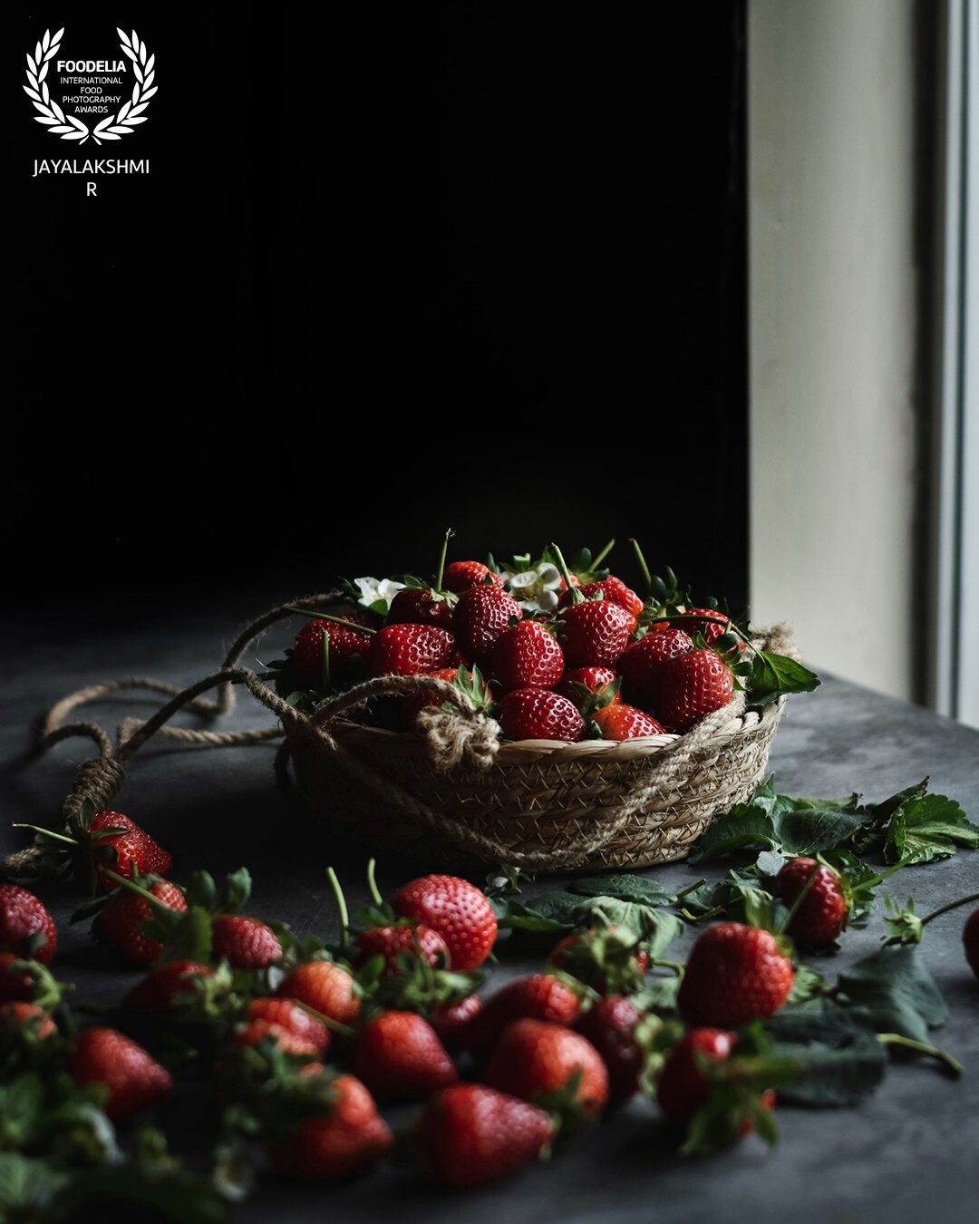 Farm fresh strawberries .Tried to showcase freshly picked strawberries in a moody setup against a window , shot in natural light .