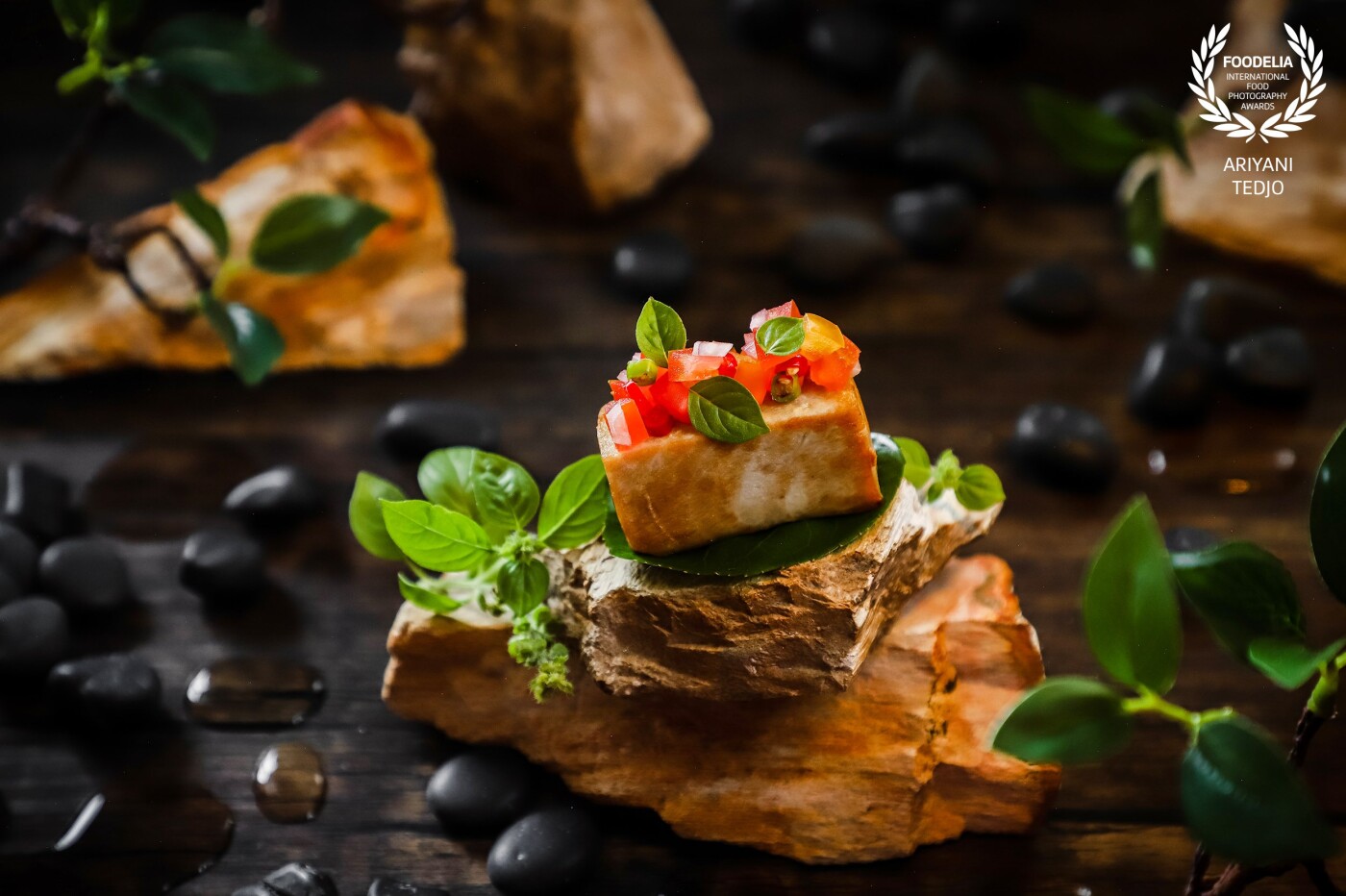 A traditional Indonesian / Manadonese dish goes fancy and a little wild. Seared tuna topped with Manado's signature salsa called Sambal Dabu-dabu. The dish is presented on a rock lined with plum aralia leaf and garnished with local basil leaves.