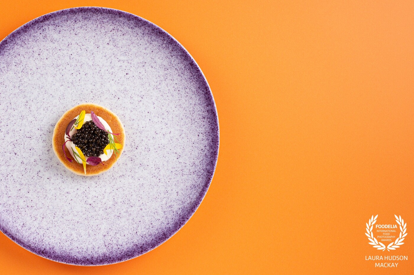 Choosing colours from the Sturia Caviar branding, creates a bold aesthetic for this delicate canapé. Collaboration with Scottish chef, Fraser Cameron. Sturia caviar blini, creme fraiche and petals.