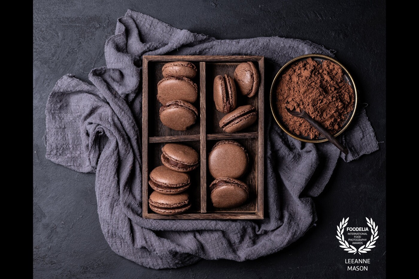 Chocolate Macarons with dark chocolate ganache lit with a large softbox from the side with a reflector just in the corner.  I love how linen and cocoa creates a gorgeous texture with the right lighting.  Whilst not perfect these Macarons definately tasted perfect!