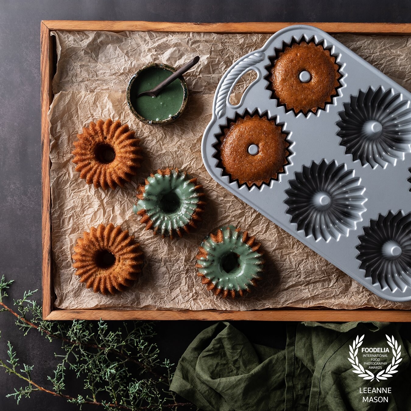 I wanted to show the texture of these adorable mini bundt cakes by using a high side light and then mixed the icing to a similar green colour as the linen and foilage.  The wooden tray served as a frame for the pan and hero food.