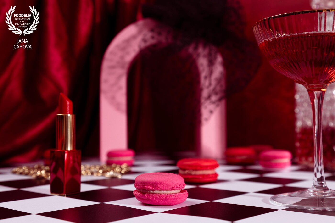 A fun photoshoot inspired by Alice in wonderland/ Emily in Paris. Red and pink macarons, petite Arc de triomphe, chessboard, red lipstick and glass of wine. …<br />
Captured in my studio with Godox lights.