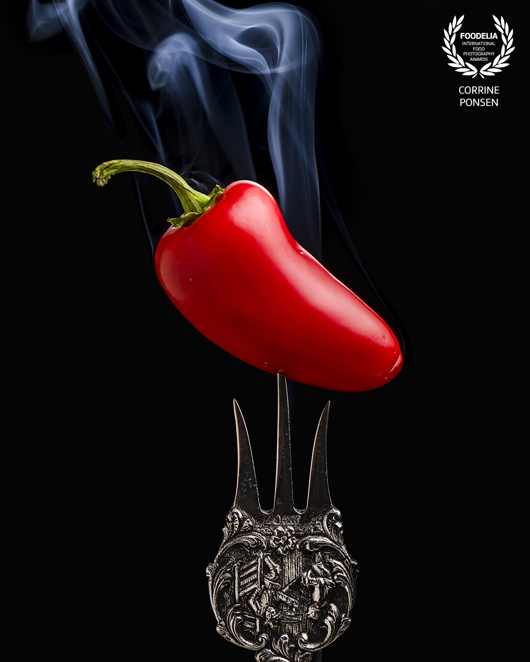 Red hot pepper on a fork. Lighted with 2 flashes on a softbox. The backlight was needed to light up the smoke.<br />
The vintage fork is just too cool.