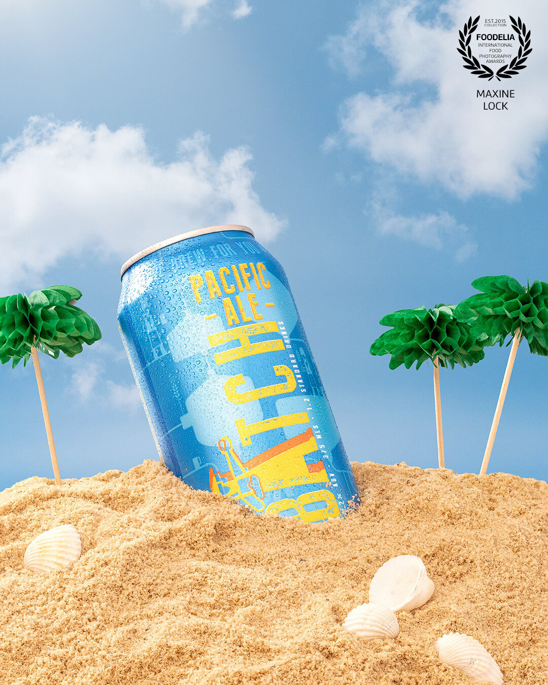 Single can of beer in a "beach in the summer" scene.  The beach scene recreated in a studio setting.