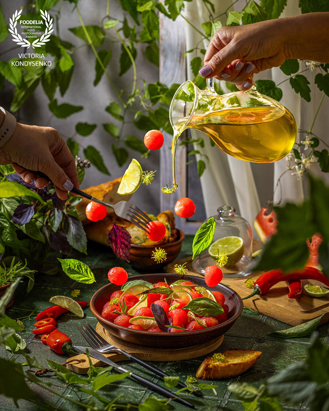 Spicy salad of fresh watermelon balls with basil, lime, rosemary and fennel, topping with olive oil. Promotional photo shoot of the local Ukrainian family cafe. Fly and splash food.