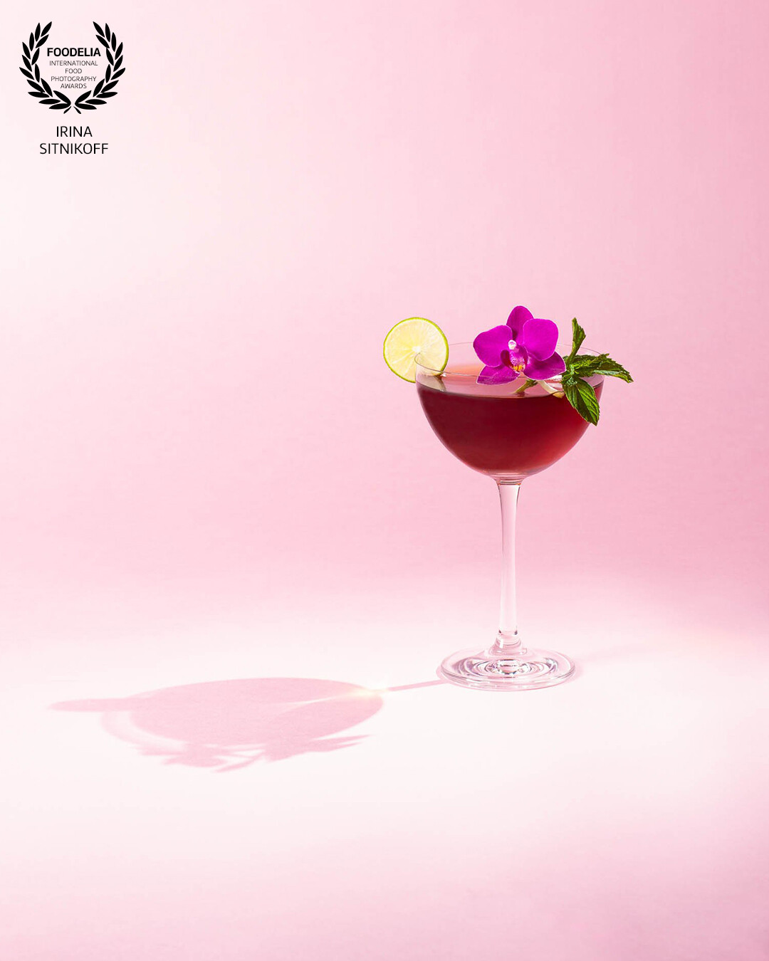 This photo was inspired by my wonderful food photography teacher & mentor Nelly Le Comte from Le Cordon Bleu. The combination of burgundy red refreshing cocktail color with fuschia colored orchid flower, piece of lime on a pink background represents love, romance and sweet emotions as well as butterflies in the stomach.